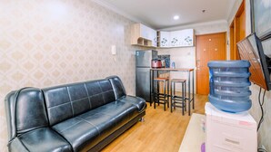 A compact living space with a sofa, kitchenette, and a water dispenser. - Nice Comfort 2Br At Cinere Bellevue Suites Apartment (Depok)