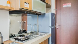 A compact kitchen with a microwave, kettle, and a stainless steel sink. - Relax And Simply Studio Apartment At Parkland Avenue (South Tangerang)