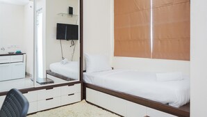 Un dormitorio con una cama, un espejo, un escritorio y una silla.