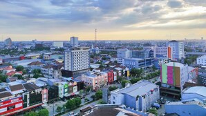 Une vue urbaine présentant divers bâtiments, dont un hôtel imposant au design moderne et à plusieurs étages.