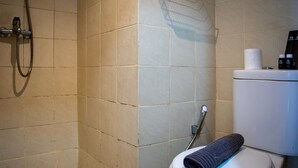 A bathroom with a shower, toilet, and a towel on the floor. - Nice And Comfort Studio Apartment At Belmont Residence Puri (Jakarta)