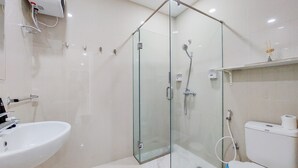 A modern bathroom with a glass-enclosed shower, a sink, and a toilet. - Strategic And Homey 2Br At Puri Garden Apartment Near Mall (Jakarta)