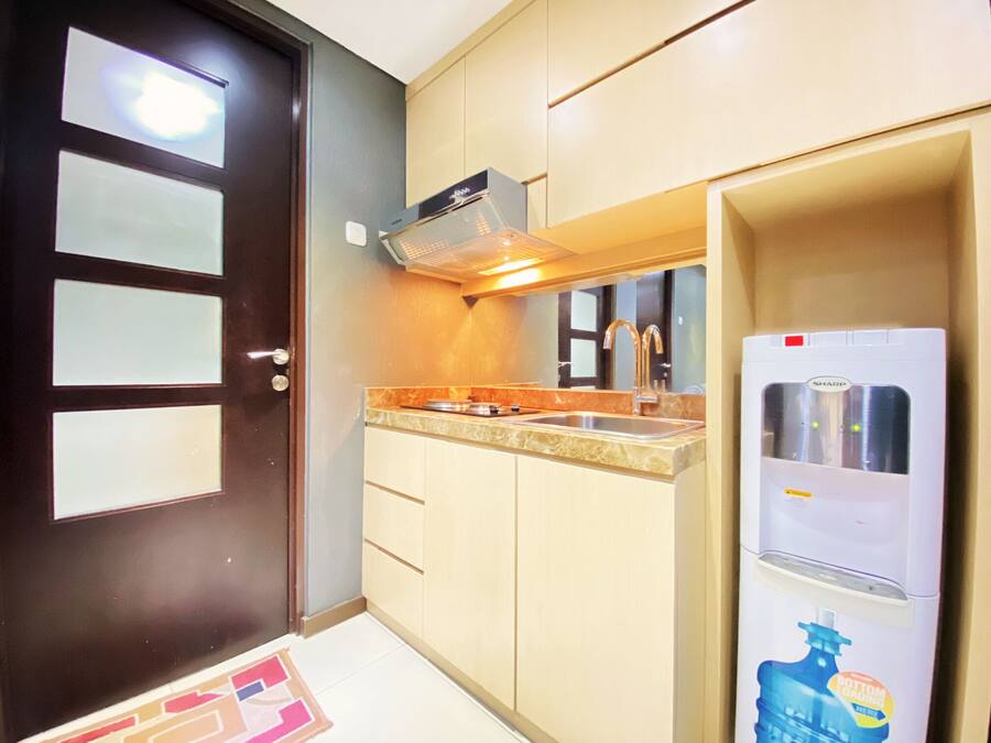 A compact kitchen with a refrigerator, a stove, and a sink.