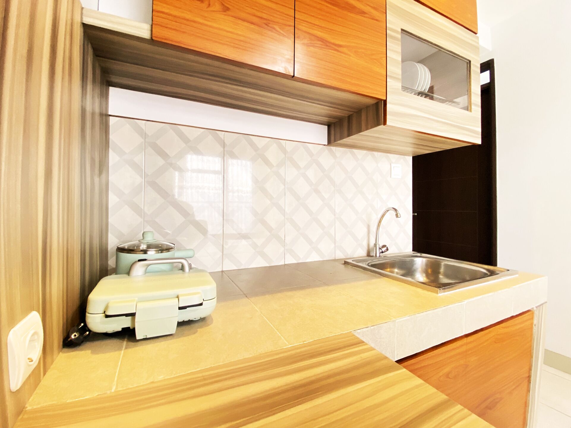 Una cocina compacta con un lavabo, una pequeña encimera y un microondas.
