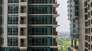 A high-rise building with multiple balconies and large windows. - Elegant And Comfy Studio At Tamansari Iswara Apartment (Bekasi)