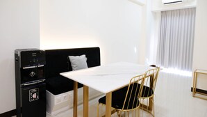 A compact living space with a sofa, a small table, and a compact kitchenette. - Spacey And Homey 2Br At Supermall Mansion Apartment (Surabaya)