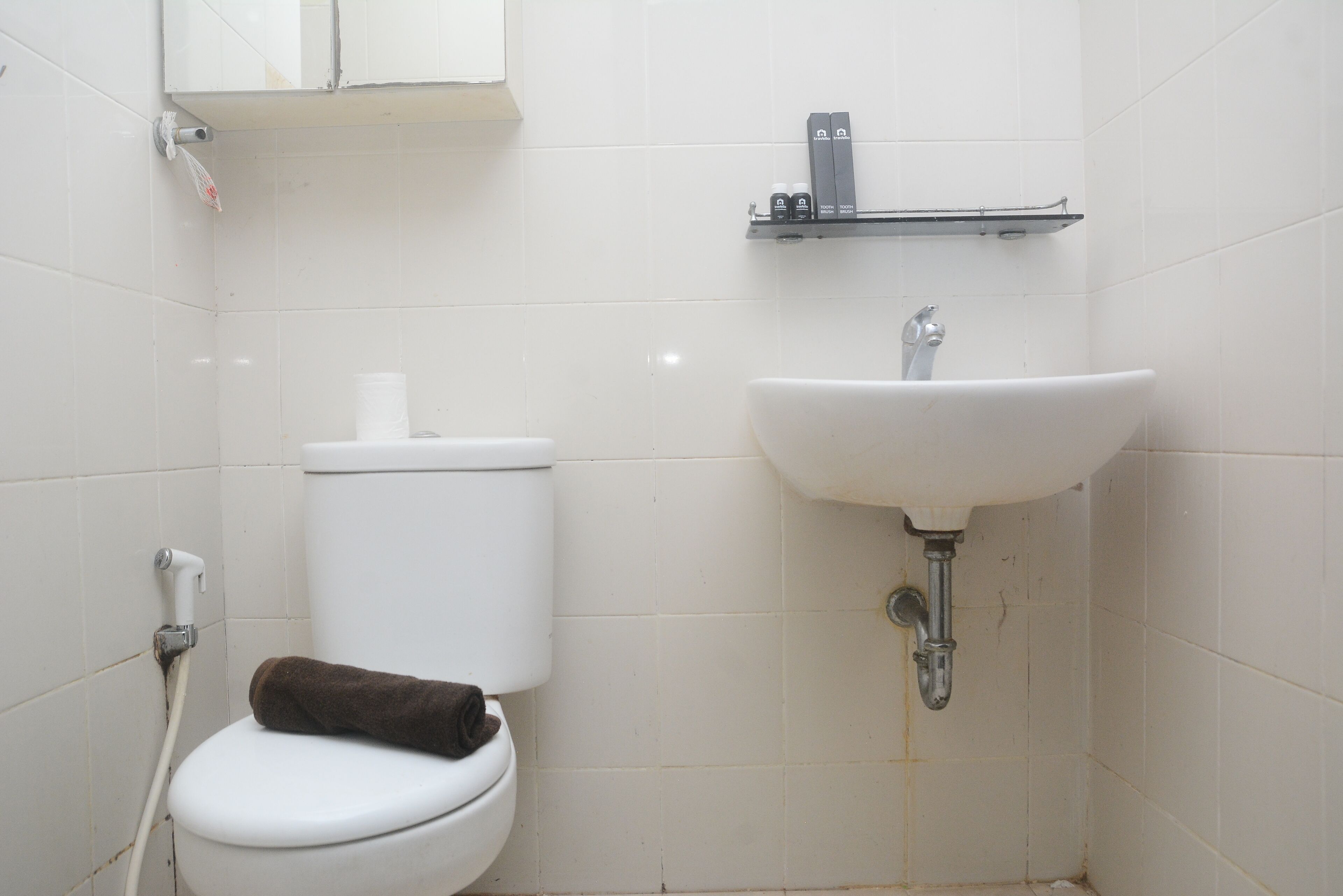 A small, clean bathroom with a toilet, sink, and a towel rack.