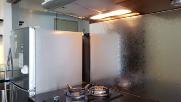 Apartamento, 2 quartos | Cozinha privada | Geladeira, cooktop, talheres/pratos/utensílios de cozinha