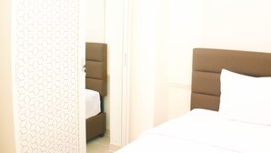 Une chambre d’hôtel avec un lit, une table de chevet et une armoire.