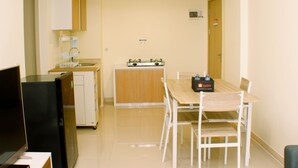 Une cuisine compacte équipée d’un réfrigérateur, d  ’une cuisinière et d’un petit coin repas avec une table et des chaises.