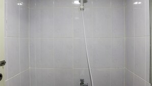 A bathroom with white tiled walls and a showerhead. - Cozy Living Studio Apartment At High Floor Tokyo Riverside Pik 2 (Teluknaga)