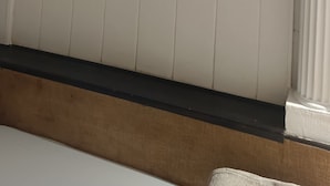 Ein Zimmer mit Oberlichter, weißen Wänden, einer Holzbalkendecke und einer weißen Fußleiste.