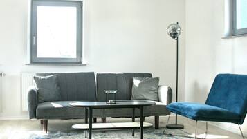 Chambre Signature | Coin séjour | TV connectée de 50 pouces avec chaßnes numériques, télévision