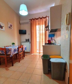 A compact living space with a dining area, kitchenette, and a single bed. - Special Family Apartment 2 Steps From the sea (Margherita di Savoia)