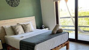 A bed with a wooden frame, a headboard, and a bedside table with a lamp. - Family Apartment in Beautiful Residential Complex in Holbox (Isla Holbox)