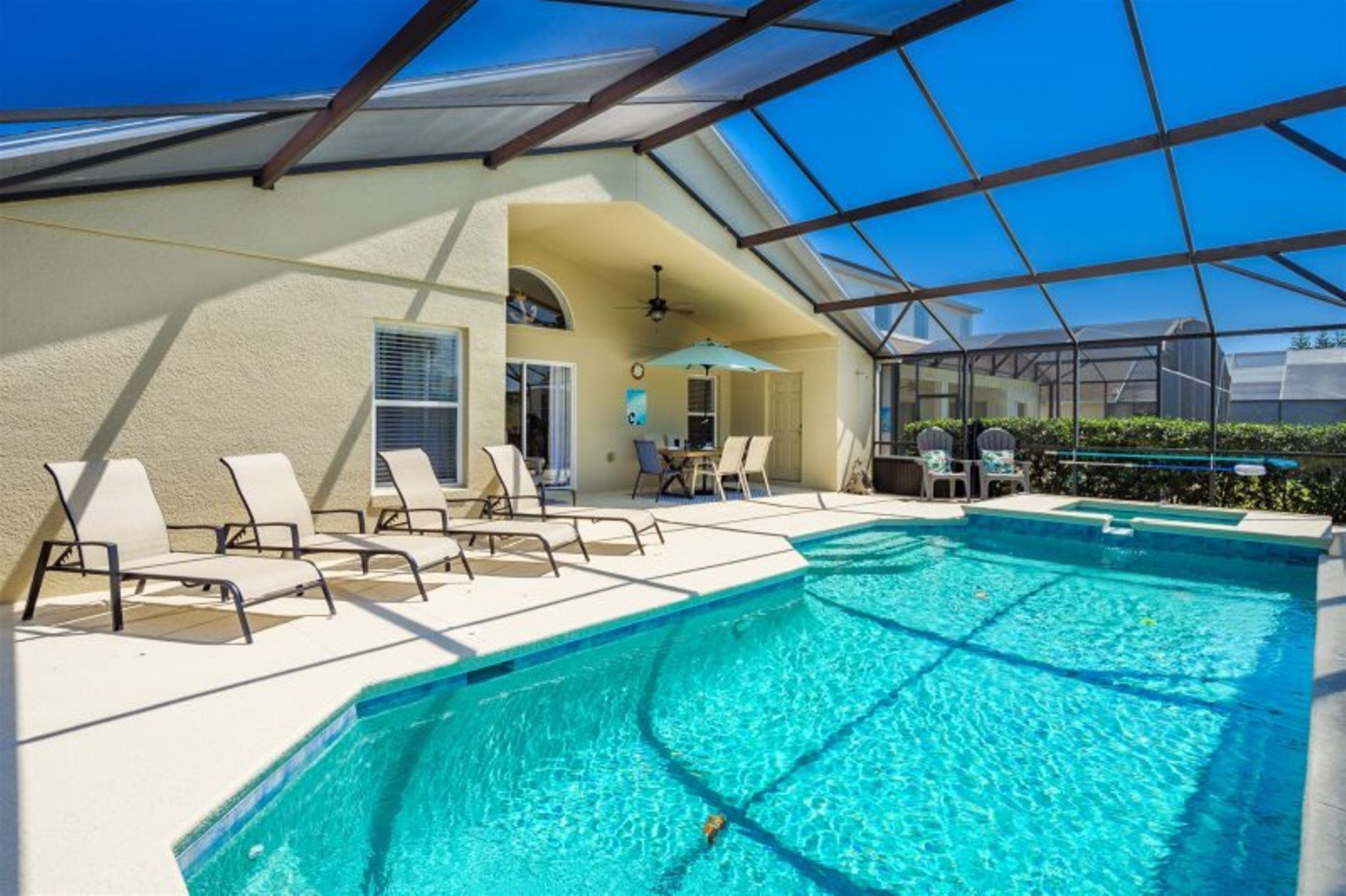 A pool area with lounge chairs and a covered section.