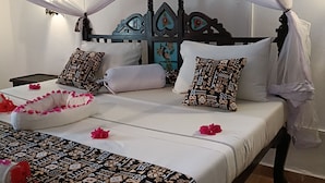 A bed with a canopy, patterned bedding, and decorative pillows. - 5-bedroom Villa - 3 Mins Walk To The Beach (Diani Beach)