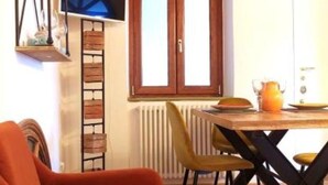 Un comedor con mesa de madera, sillas y una lámpara colgante.