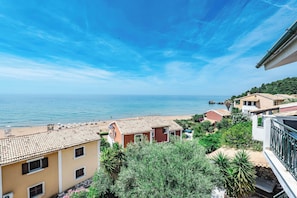 Eine Wohngegend an der Küste mit Blick auf das Meer, mit Häusern mit Ziegeldächern und viel Grün.