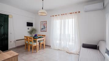 Un espacio habitable compacto con comedor, sofá y televisor.