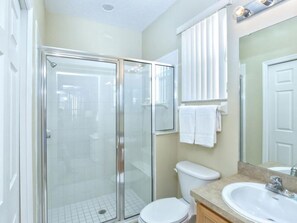 A bathroom with a glass-enclosed shower, a toilet, a sink, and a mirror. - 5 Bedroom Executive Home - Private Pool and Spa (Davenport)