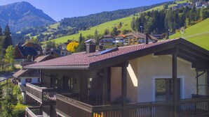 Un chalet doté d’un balcon, niché au cœur d’un paysage montagneux.