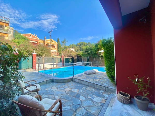 Relax by the serene pool surrounded by a stone patio and comfortable wicker chairs.