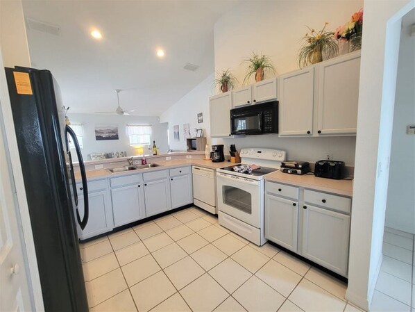 Enjoy cooking in this well-equipped kitchen with a refrigerator, microwave, oven, and sink.