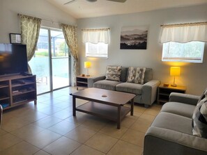 Relax in this inviting living room with a sofa set, coffee table, and TV on a stand.