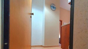 A hallway with a doormat that reads "HOME SWEET HOME" and a clock on the wall. - Beautiful Family Apartment in the Center (Margherita di Savoia)