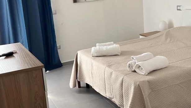 Une chambre d’hôtel avec un lit, un bureau et un miroir.