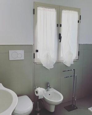 Ein Badezimmer mit zwei Waschbecken, einem Bidet und einer Toilette.