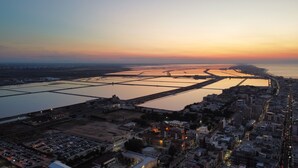 An aerial view of a coastal city with a large body of water, extensive water management infrastructure, and dense urban development. - Splendid Quadruple in the Center, 2 Steps From the sea (Margherita di Savoia)