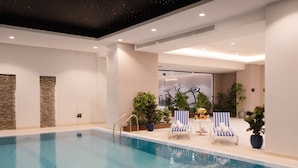 An indoor swimming pool with clear water, surrounded by lounge chairs and potted plants. - Cantonal Hotel Riyadh (Riyadh)