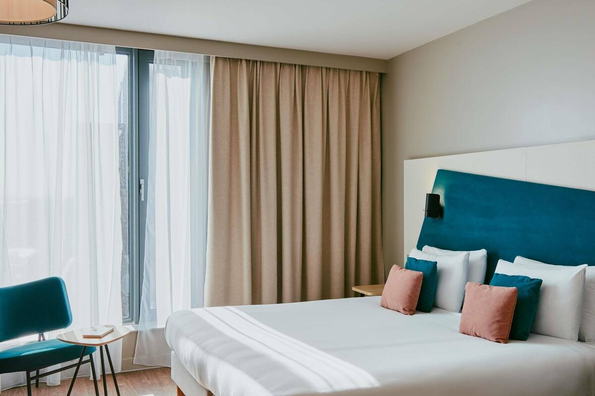 Een hotelkamer met een groot bed, een bureau en een stoel.