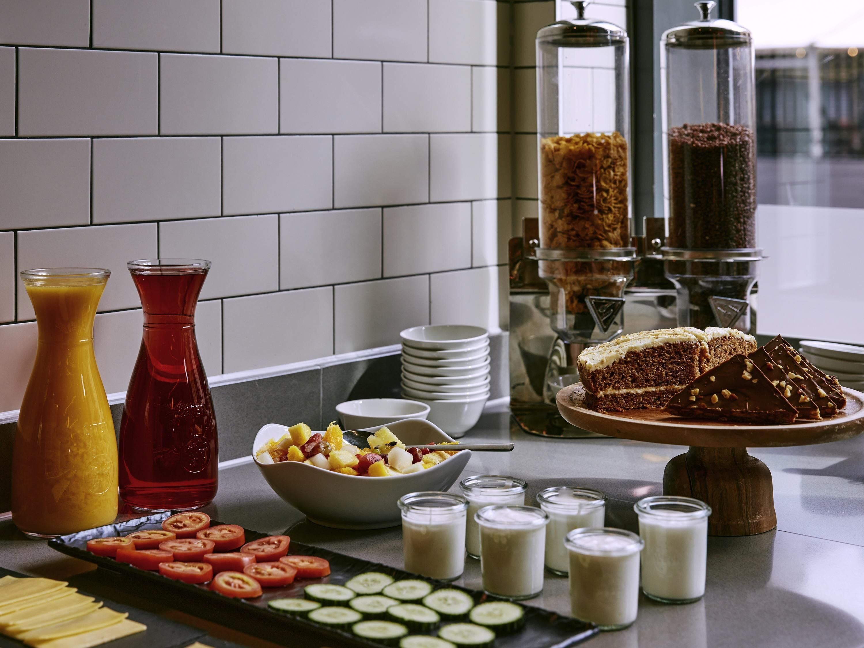 Ein Frühstücksbuffet mit verschiedenen Speisen, einer Kaffeemaschine und einer Obstschale.