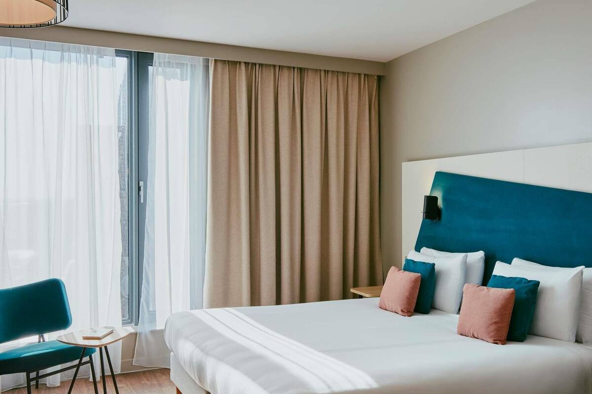 Una habitación de hotel con una cama grande, un escritorio y una silla.