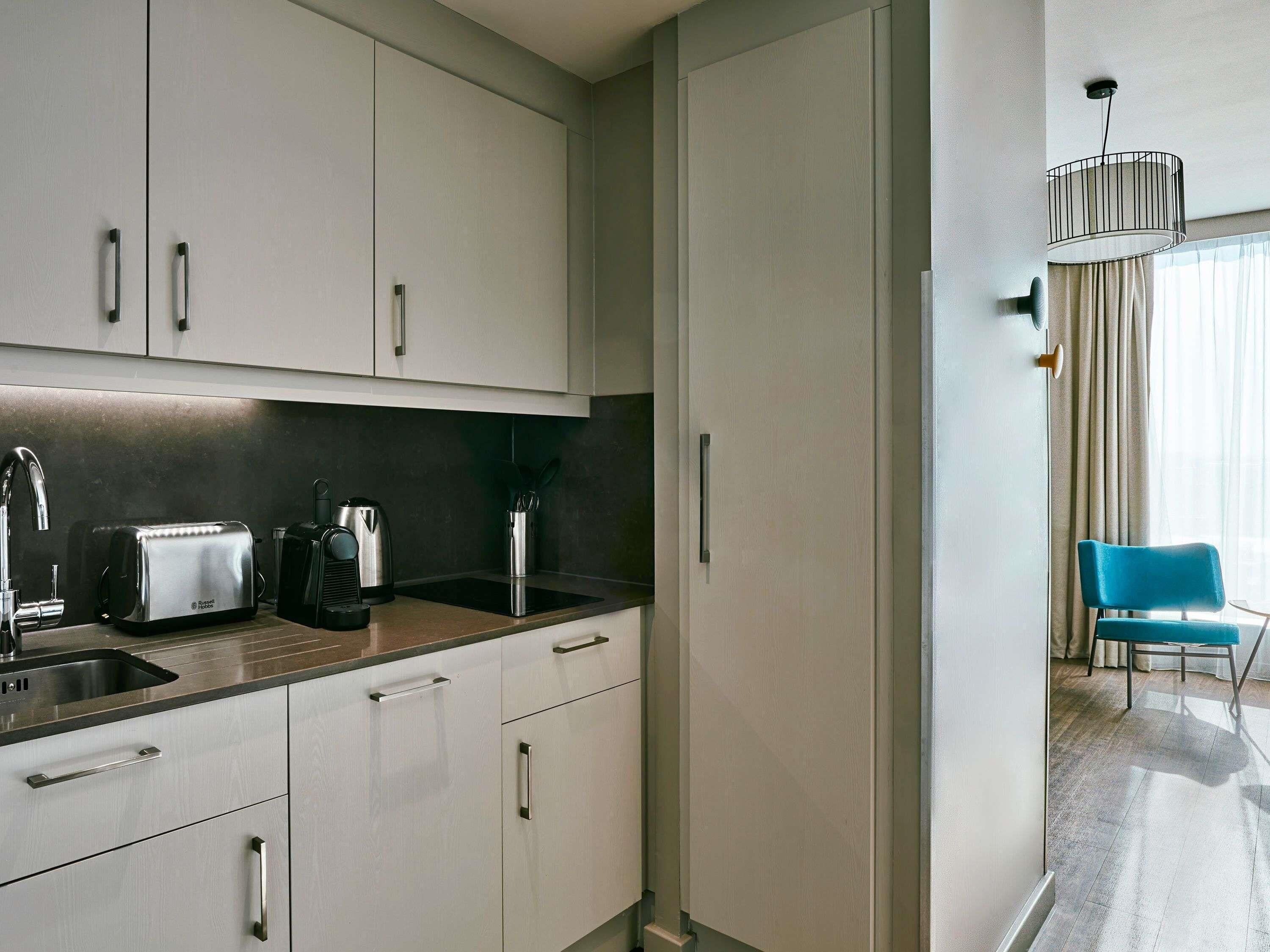 Een moderne keuken met roestvrijstalen apparatuur, een inbouwoven en een spoelbak.