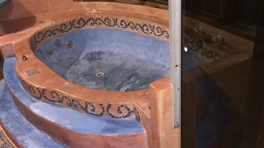 Ein Whirlpool mit einer gefliesten Kante und Stufen, die zu ihm führen.