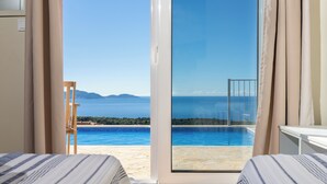 A hotel room with a view of a swimming pool and the sea. - Villa Dioni-Ocean view from every room, spacious and very clean. (Magganos)