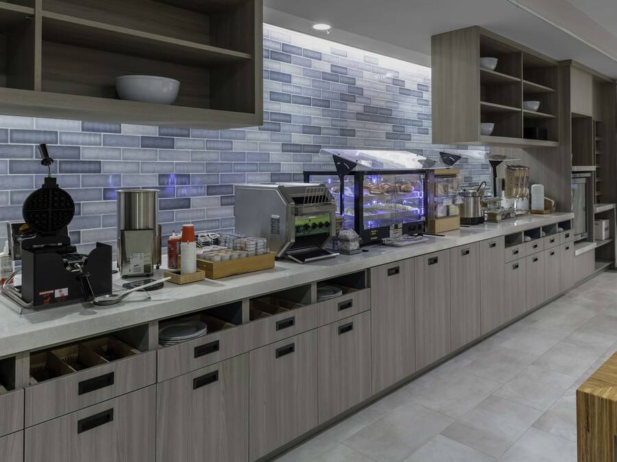 Een moderne keuken met een lange aanrecht, inbouwapparatuur en opbergkasten.