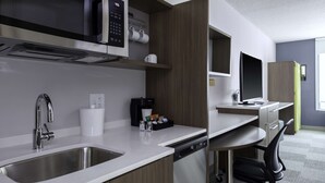 A modern kitchen with a built-in microwave, coffee maker, and a dishwasher. - Home2 Suites by Hilton Covington (Covington)
