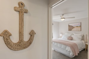 A bedroom with a bed, a ceiling fan, and a wall-mounted anchor decoration. - Hidden Little Gem – Luxury Township Escape in Middleton (Middleton)