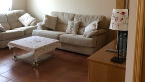 A living room with two sofas, a coffee table, and a wooden cabinet. - The flax orchard. (Candeleda)