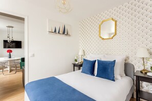 Una habitación de hotel con una cama grande, un comedor y un televisor.