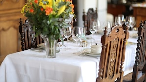 A dining table set with white tablecloth, glassware, and a floral centerpiece. - Domaine GILLE (Comblanchien)