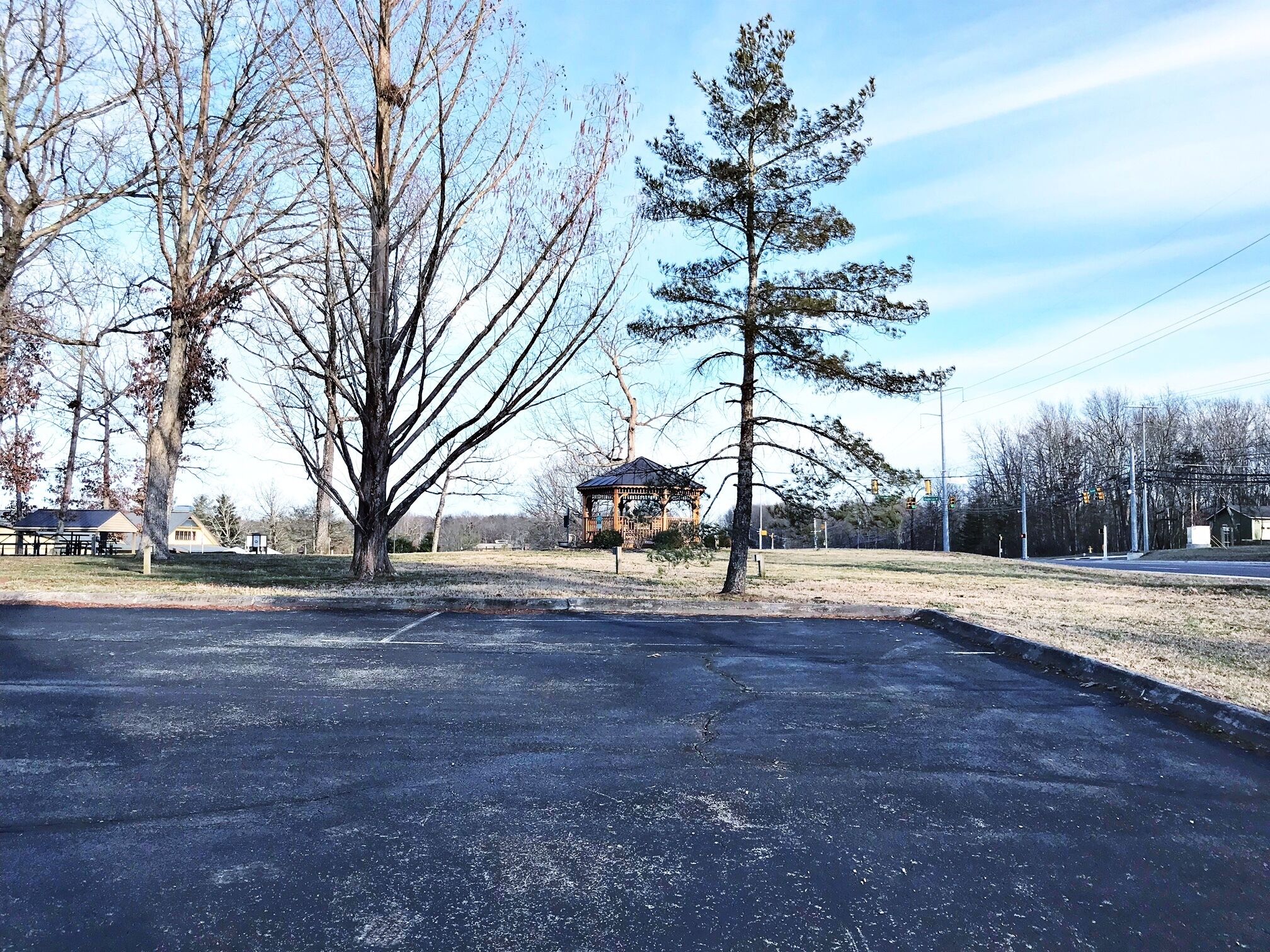 A parking lot with a gazebo and picnic tables.