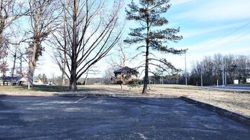 A parking lot with a gazebo and picnic tables.