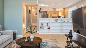 Una sala de estar moderna con un sof á, una mesita de centro y una estantería llena de juguetes infantiles.