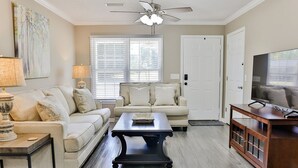 A living room with a sofa, coffee table, TV stand, and ceiling fan. - 2 King Bed Master Suites and 1/2 Mile from Chief  Ladiga Trails and Elwell Park (Weaver)